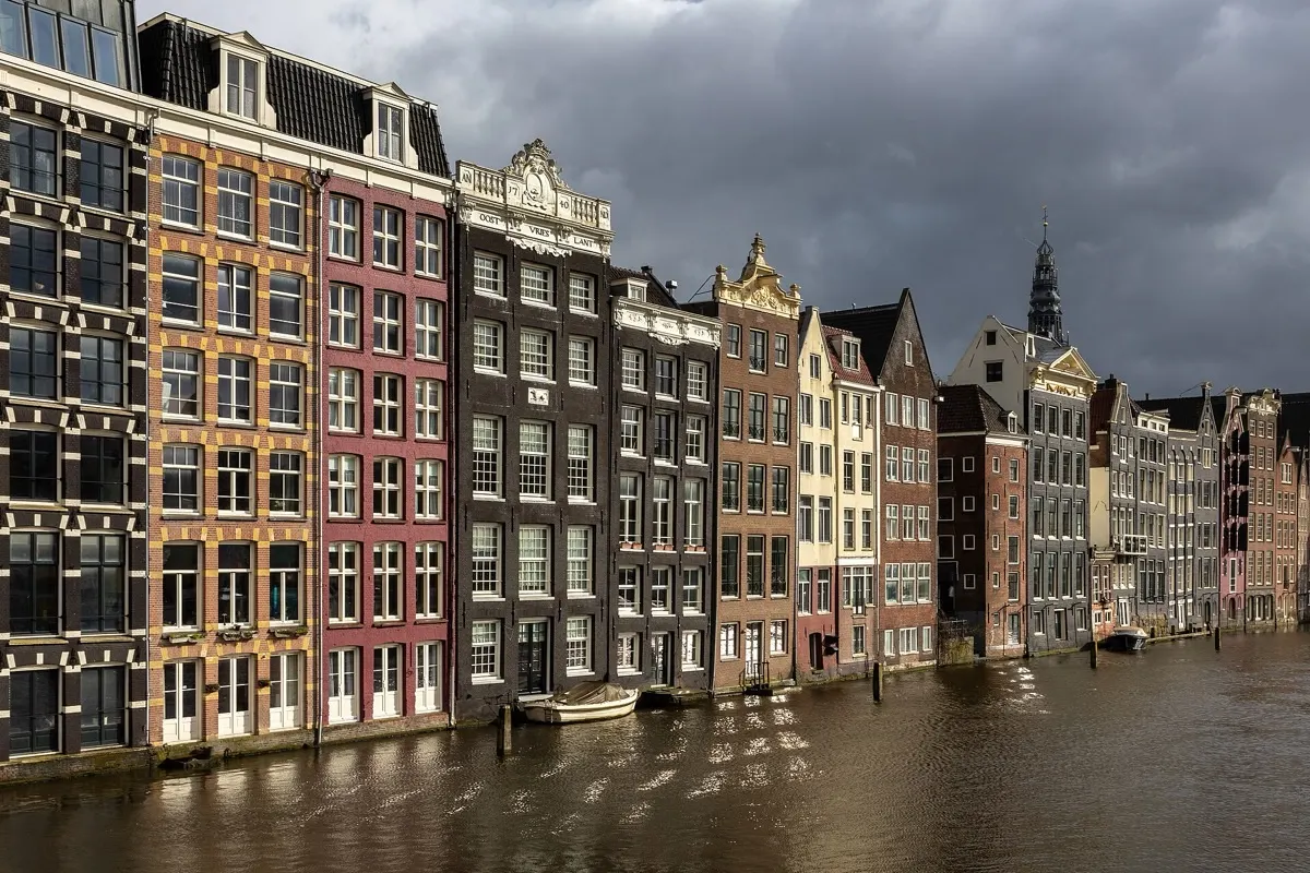 Colorful canal houses along the Damrak in Amsterdam at golden hour