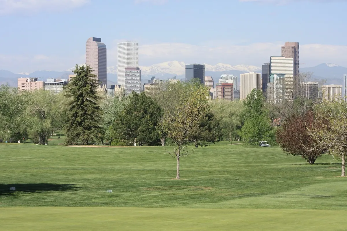 Denver skyline with snow-capped Mount Evans behind, seen from City Park